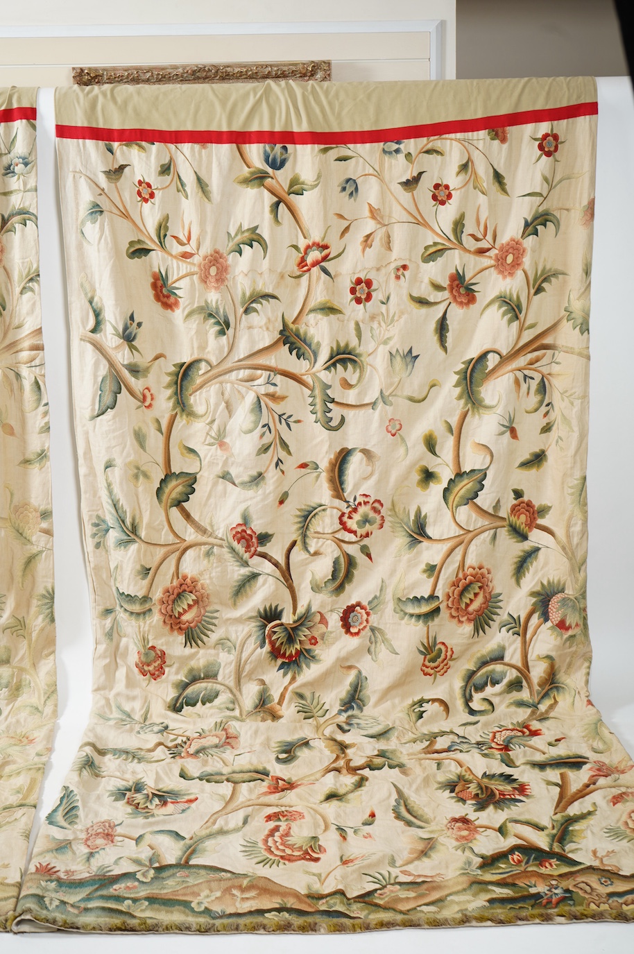 Six 20th century crewel work ‘Tree of Life’ cream linen curtains. Worked at the base in coloured wools depicting a pastoral scene of a shepherd playing a flute amongst sheep, deer, squirrels and flowers with a dog chasin